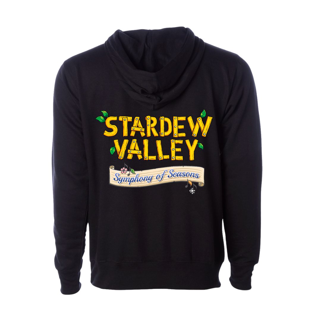 Black hoodie featuring a vibrant yellow ’stardew valley’ graphic with green leaf accents and a beige banner reading ’symphony of seasons.’