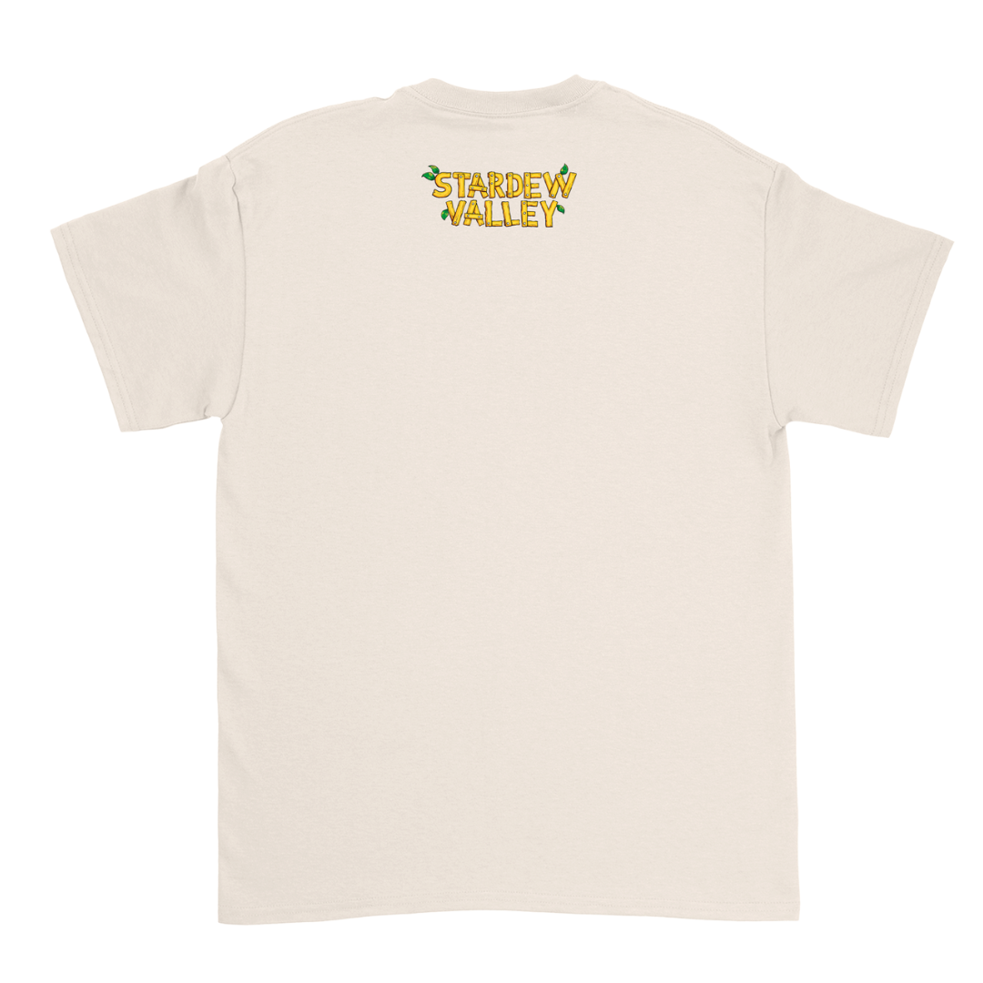 Cream-colored short-sleeved t-shirt with ’stardew valley’ printed in yellow and green on the back.