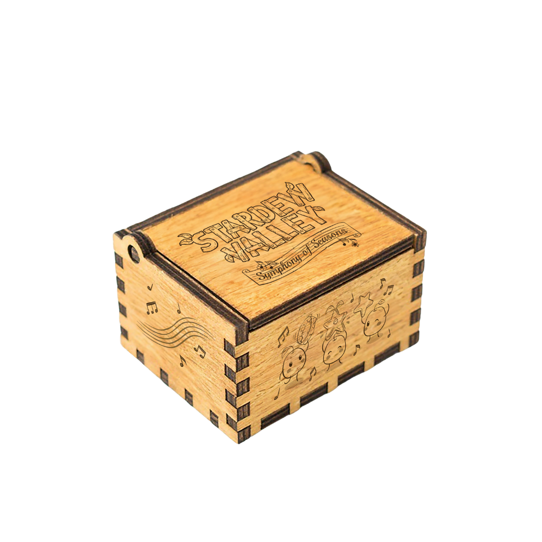 A light wood-grain music box with darkened laser-engraved edges and decorative musical notes, cartoon characters, and the text ’stardew valley: symphony of seasons’ on its lid.