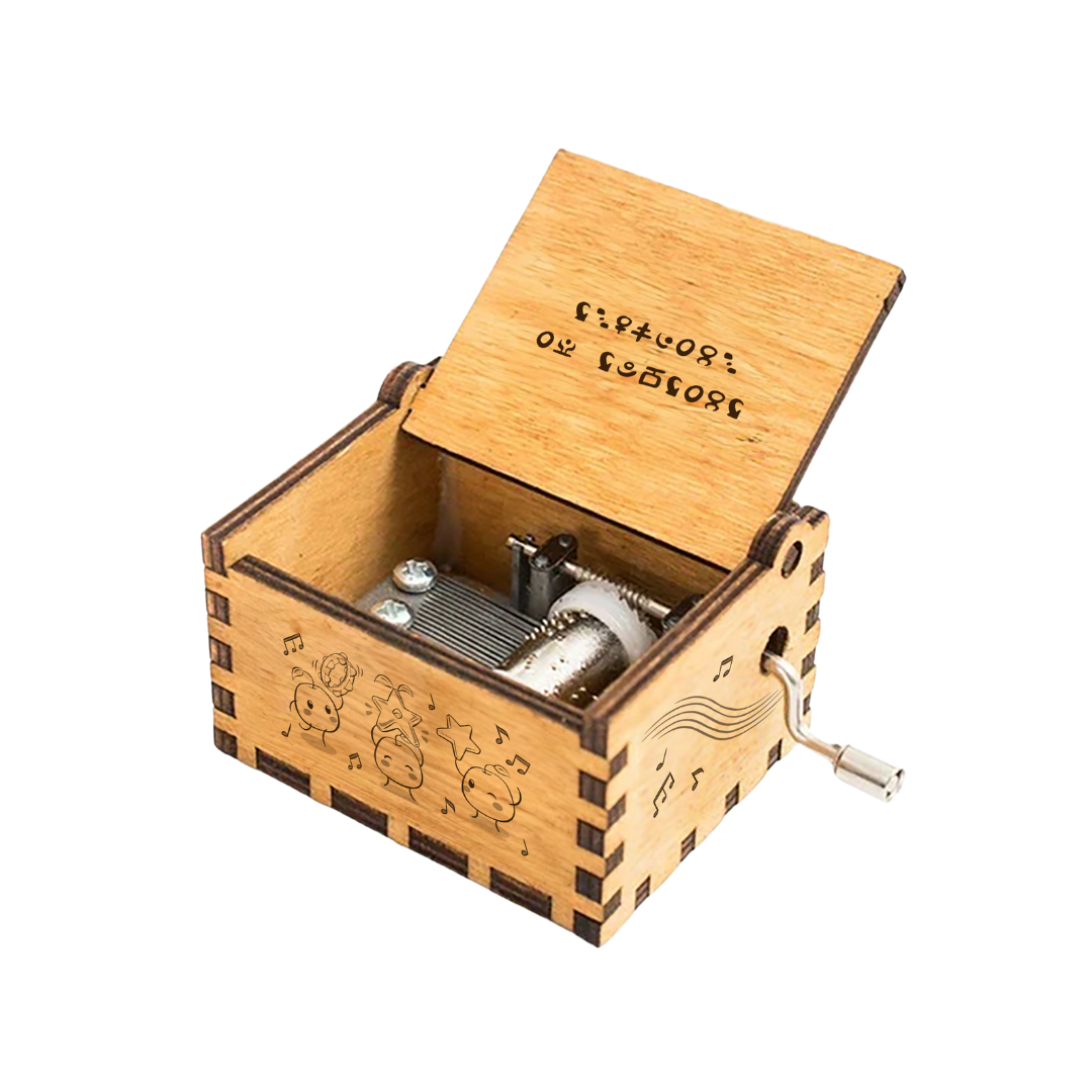 A light brown wooden music box with engraved cartoon characters and musical notes, featuring a silver hand crank on the side.